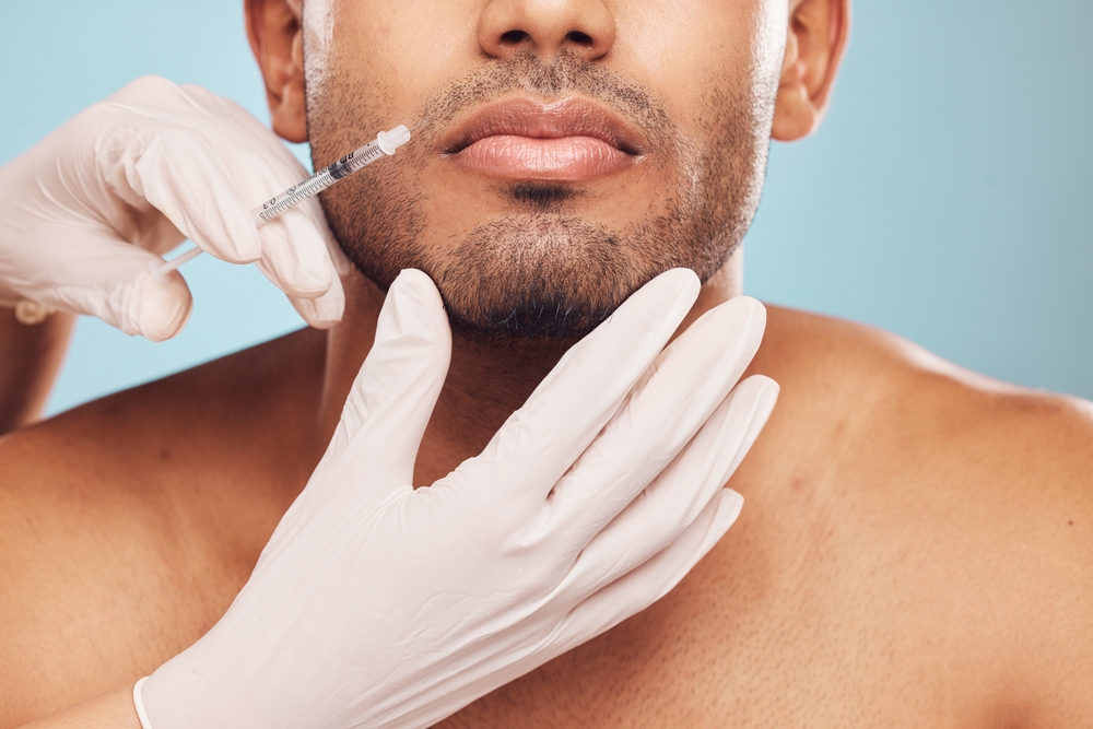 An athletic man receiving a Botox injection to his upper lip.